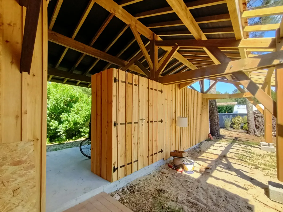 Charpente bois apparente d'un abri, avec un bardage en planches