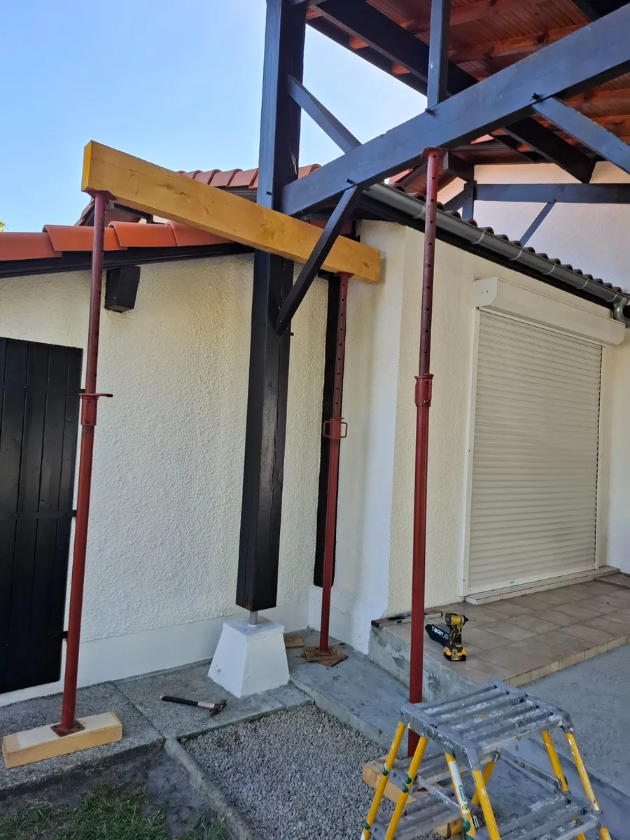 Structure en bois soutenue par des étais et une poutre provisoire avant la reprise d'un poteau
