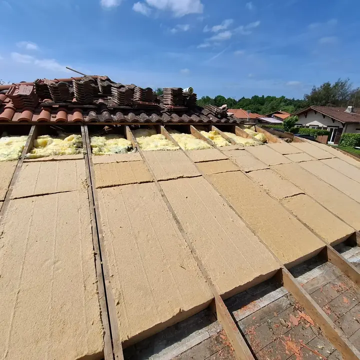 Dépose des tuiles et pose de l'isolation pendant une rénovation de couverture